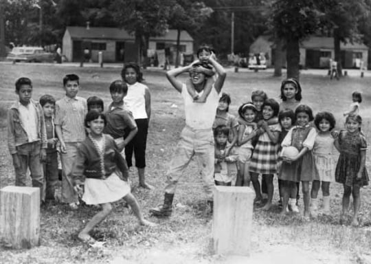 Black and white photograph of Mexican American migrant farm-worker children playing, ca. 1960.